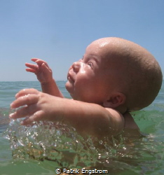 My son in the sea for the first time by Patrik Engstrom 